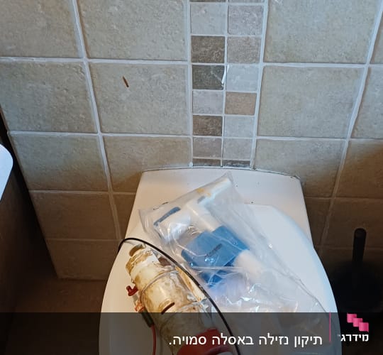 חלקי אינסטלציה על אסלה בחדר אמבטיה